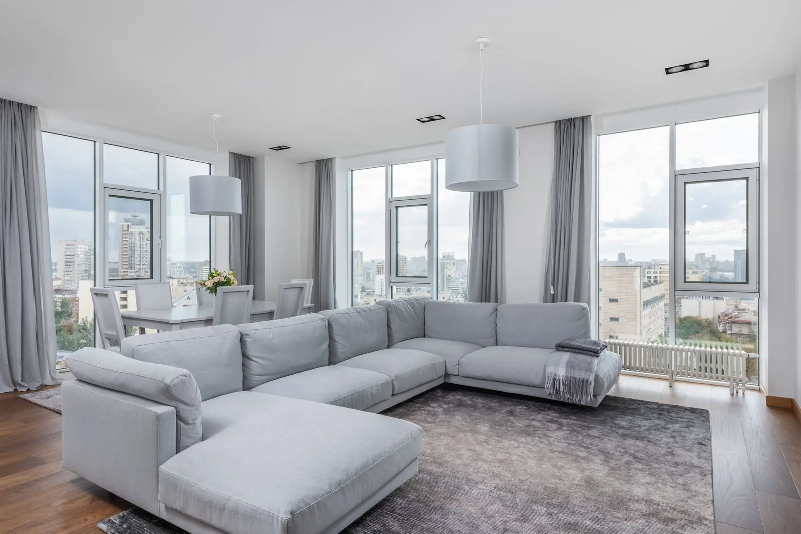 Bright high-rise condo living room with a grey sectional and floor-to-ceiling windows