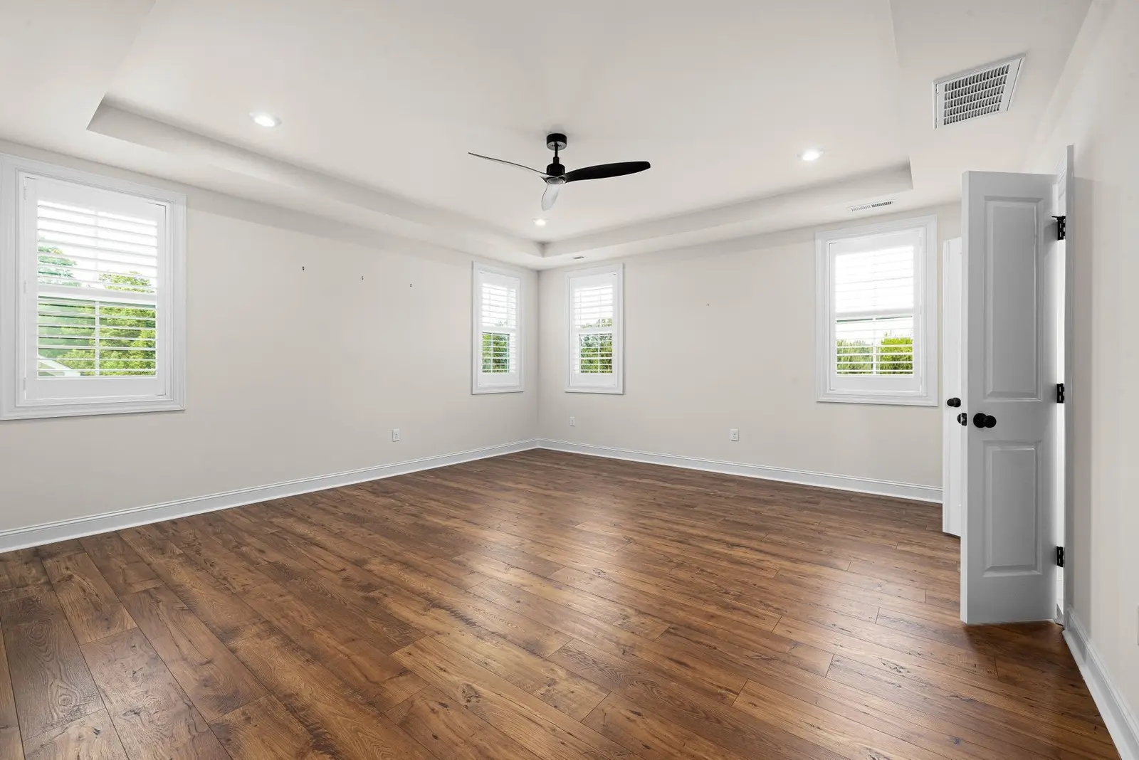 Empty room with bare wood floors and windows
