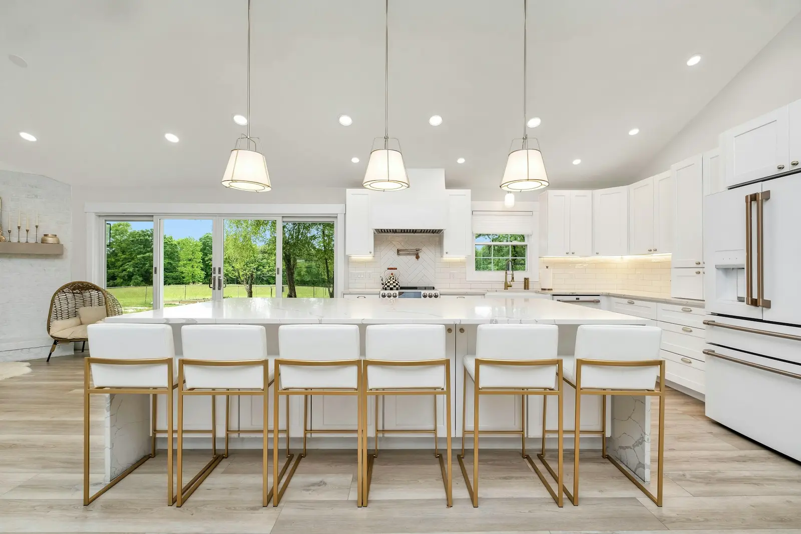 Bright white shaker kitchen with a large quartz island and pendant lights